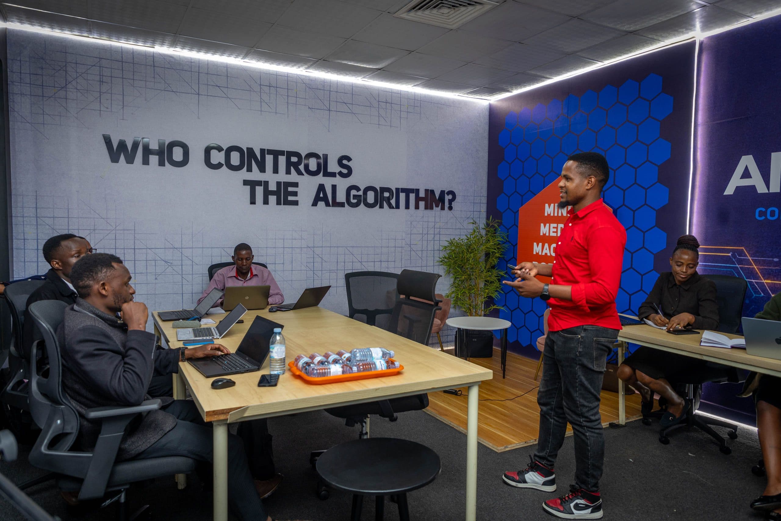 The AI Media Lab studio in Kampala: participants working at laptops around long desks.